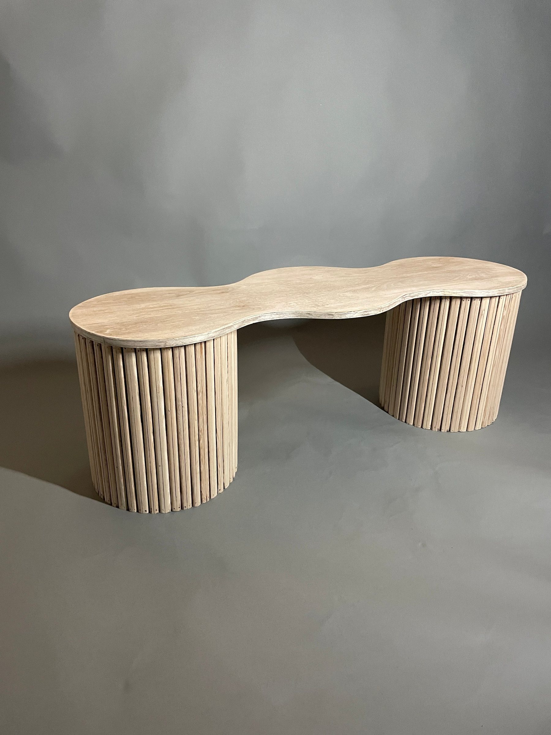 A kidney-topped bench on fluted drum bases in reclaimed douglas fir